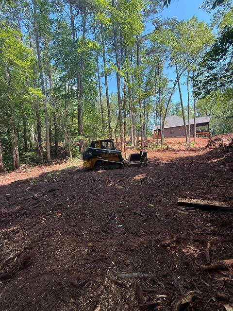 Skid steer clearing a wooded homesite